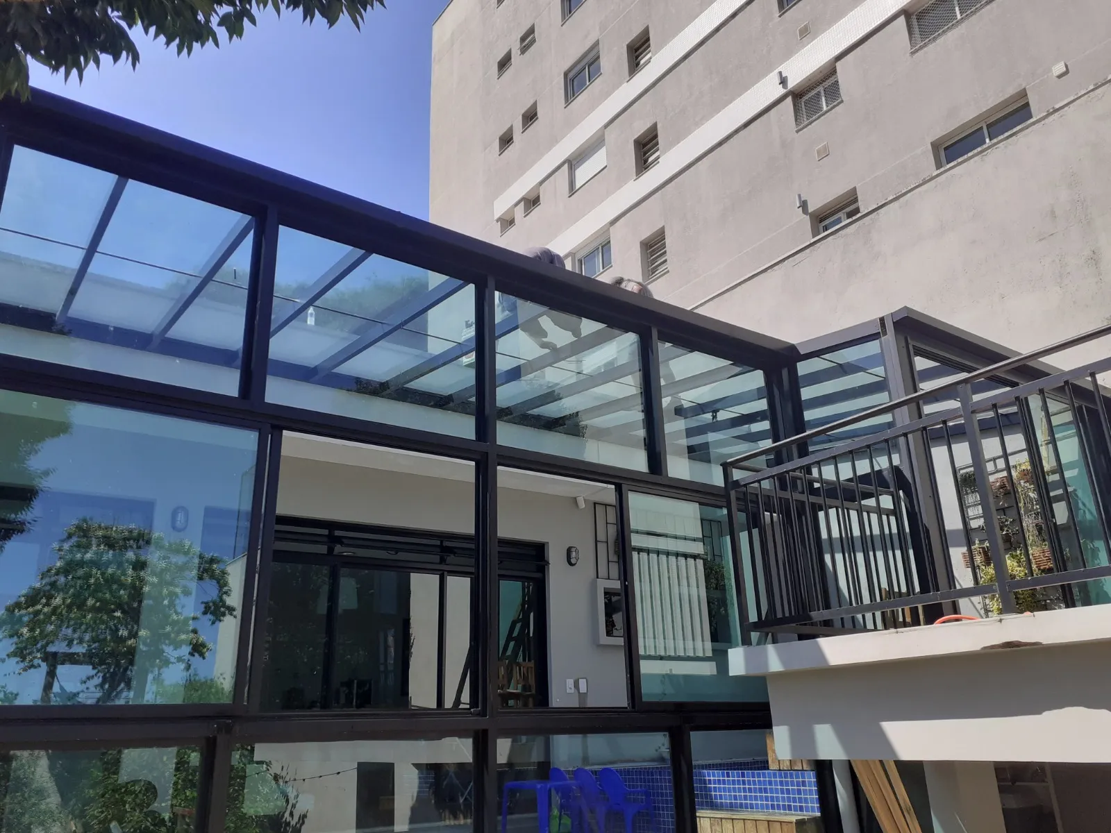 Uma moderna e elegante cobertura de vidro em uma área externa residencial.