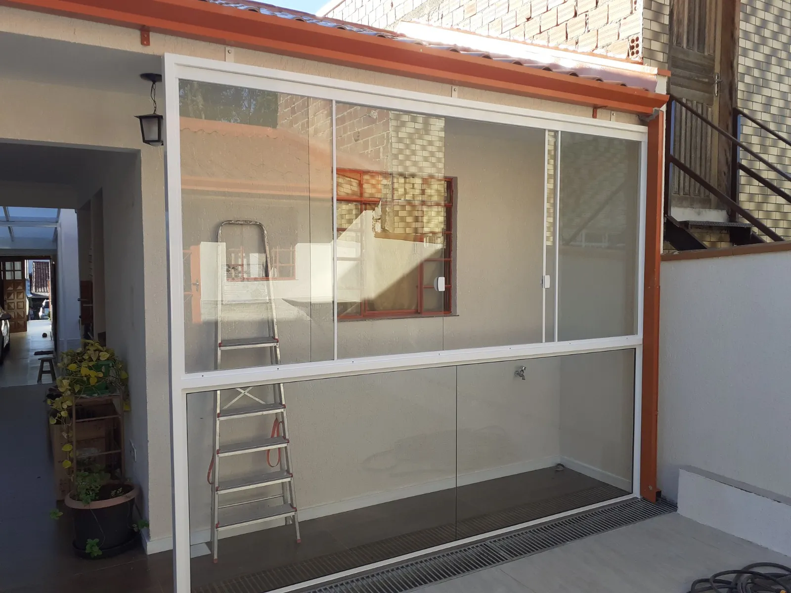 Fechamento de área com painéis de vidro deslizantes.